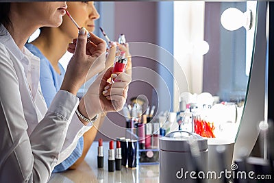 Closeup makeup artist teaching woman client applying lip gloss at lesson make up for yourself Stock Photo