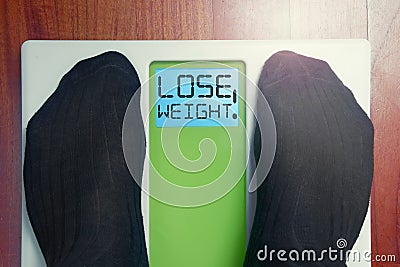 Closeup male feet on scale at morning lose weight words Stock Photo