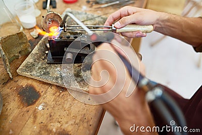 Artisan Melting Metal in Workshop Stock Photo