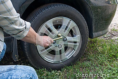 Closeup of male hands using a wrench for a car tire. Wheel replacement after an accident in a sunny day. Show car repair by car ow Stock Photo