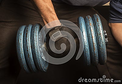 Home: Close up of a man doing rows with a blue dumbbell. 9 Stock Photo