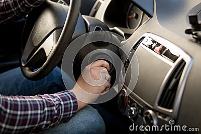 Closeup of man inserting key in car ignition lock Stock Photo