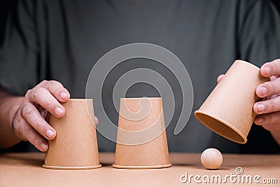 Three cups with wooden ball, Shell Game Stock Photo