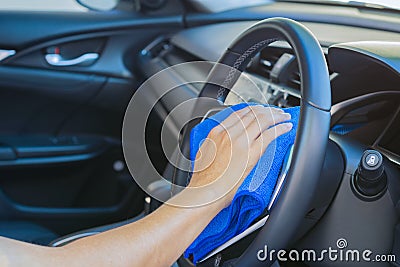 Closeup for man polishing cleaning car steering wheel with microfiber cloth Stock Photo