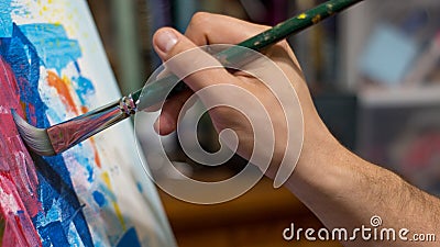 Closeup of man`s hand painting an acrylic or oil abstract picture o Stock Photo