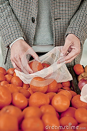 Man using a reusable mesh bag at a greengrocer Stock Photo
