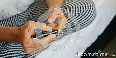 man pricking his finger with a fingerstick, banner format Stock Photo