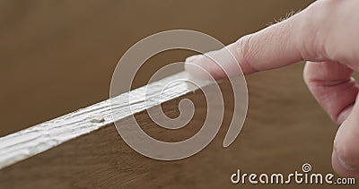 Closeup man spreading wood glue on oak board with finger Stock Photo