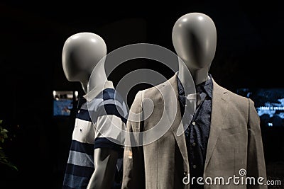 Closeup of mannequins with a suit and a t-shirt on them against a dark bac Stock Photo