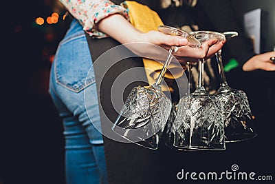 Closeup many upside down empty clear transparent crystal upturned wine glasses hanging in straight rows on brown wooden Stock Photo