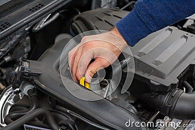 Closeup of mechanic hands checking motor under the hood in the broken car. Repairing of the vehicle concept. Automobile service Stock Photo