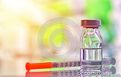 Closeup of medicine vial or flu, measles vaccine bottle with syringe and needle for immunization on vintage medical background, Stock Photo