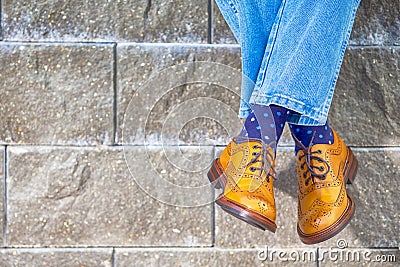 Closeup of Mens Legs Wearing Brown Oxfords Semi Brogues Shoes. Posing Outdoors Against Stony Grunge Background Stock Photo