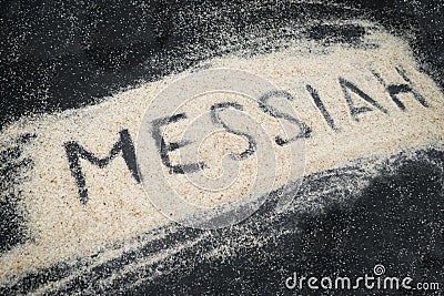 Closeup of MESSIAH text written on white sand Stock Photo