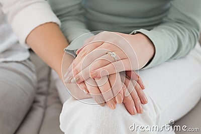 Closeup mid section of female friends touching hands Stock Photo