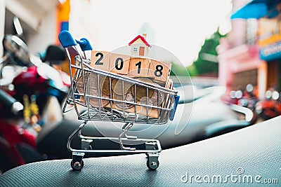 Closeup mini shopping cart contain mini house Stock Photo