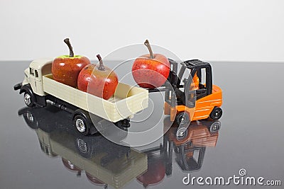 Closeup of a miniature figure of a worker in a forklift unloading the apples in a truck Stock Photo