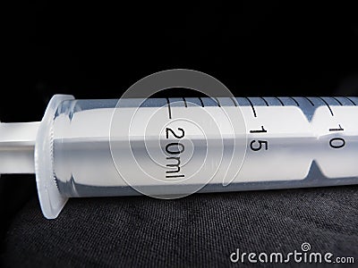 Closeup of a 20 ml syringe- Medical equipment studio shot with black background Stock Photo