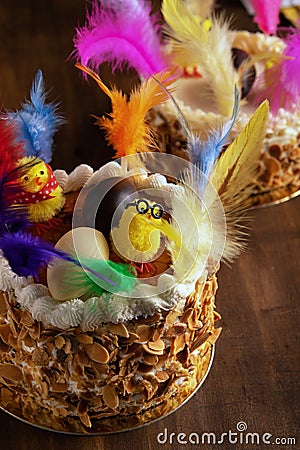 Closeup of a mona de pascua, a cake eaten in Spain on Easter Monday, ornamented with feathers and a teddy chick on on a rustic Stock Photo