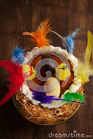 Closeup of a mona de pascua, a cake eaten in Spain on Easter Monday, ornamented with feathers and a teddy chick on on a rustic Stock Photo