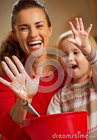 Closeup on mother and baby hands smeared in flour Stock Photo