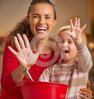 Closeup on mother and baby hands smeared in flour Stock Photo