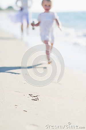 Closeup on mother and baby running along sea shore Stock Photo