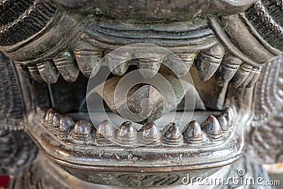 Closeup of the mouth is full of fangs of bronze lion statues for background Stock Photo