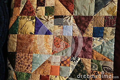 Closeup multicolored squares and triangles Amish Handmade Quilt2 Stock Photo