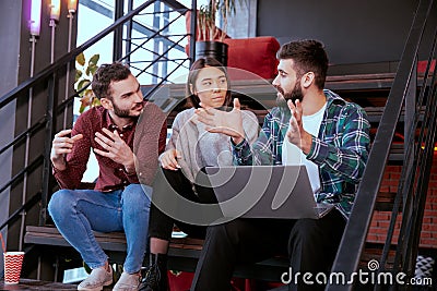 Closeup multiethnic students analyzing happy and excited their project for the college using a notebook they chatting Stock Photo