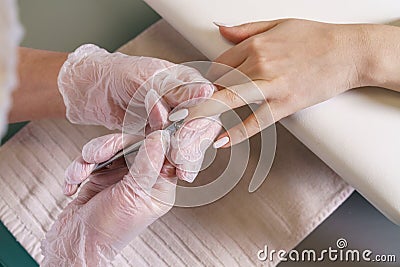 Closeup nail care by manicure specialist in beauty salon. Manicurists clean Stock Photo