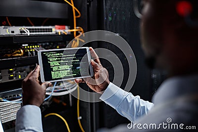 Closeup network engineer using tablet while setting up servers Stock Photo