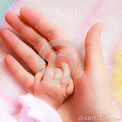 Closeup newborn baby holding his mothers finger Stock Photo
