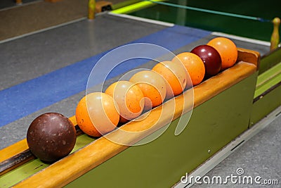 Closeup of old colorful bowling balls on a row under the lights Stock Photo