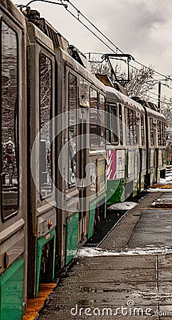 Closeup of an old grungy trolley driving past a station in winter in Brookline Editorial Stock Photo