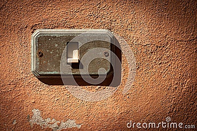 Old and rusty Light Switch on a red wall - Liguria Italy Stock Photo