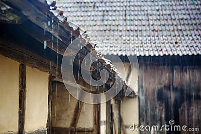 Old vintage roof of cottage with pouring rain Stock Photo