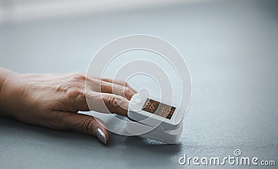 Closeup old woman`s hand for self blood oxygen monitoring Stock Photo