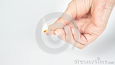 Older womans hand holding a burning matchstick Stock Photo