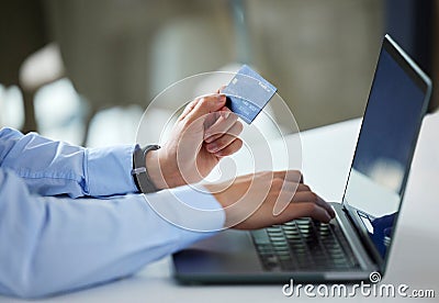 Closeup of one businessman spending money online with a credit card and laptop in an office. Making purchase transaction Stock Photo