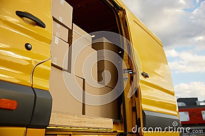 Closeup opened mini van doors and cardboard parcel boxes inside Stock Photo