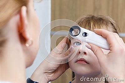 A closeup of an ophthalmologist checking the eye of a child Stock Photo