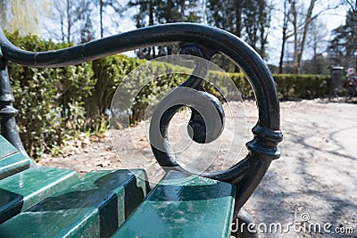 Closeup ornate black railing vintage park bench Stock Photo