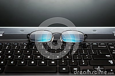 Closeup pair of glasses on the laptop keyboard Stock Photo