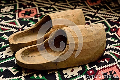 Closeup of a pair of wooden shoes on a beautiful carpet. Stock Photo