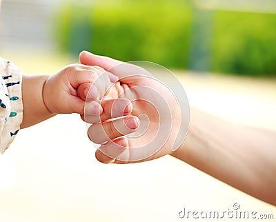 Closeup parent and baby holding hand together Stock Photo