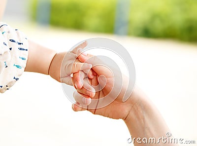 Closeup parent and baby holding hand together Stock Photo