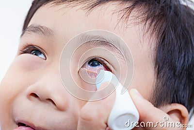 Closeup of parent pouring eye drops in eye her son Stock Photo