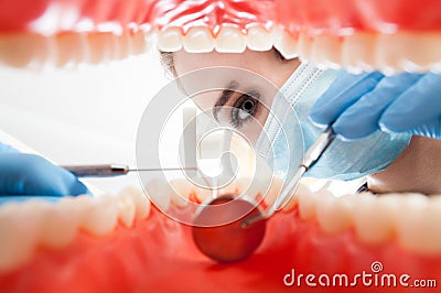 Closeup patient mouth with teeth being checked by woman dentist Stock Photo