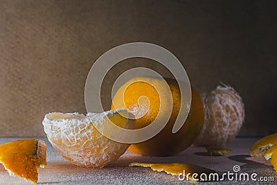 Closeup of peeled and whole tangerines on a table with a blurry background Stock Photo